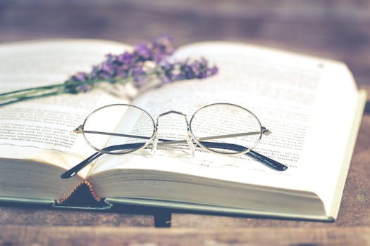 A serene close-up of eyeglasses resting on an open book with lavender flowers, emphasizing calm and reading pleasure.